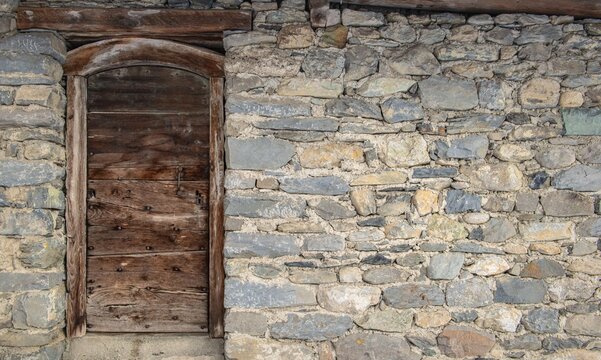 Background stone wall  and wooden door from n old chalet in Savoy