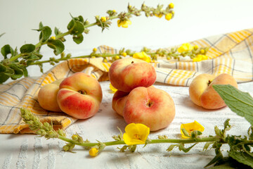 Several whole saturn peaches or flat peach on white wooden background..