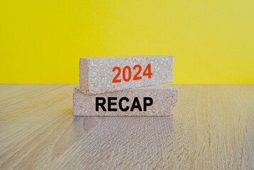 2024 RECAP symbol. Concept orange words 2024 RECAP on brick blocks. Beautiful wooden table, yellow...
