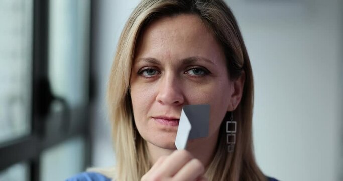 Woman victim of abuse tearing gray tape from mouth 4k movie slow motion