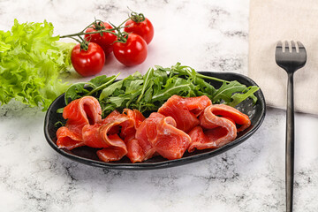 Sliced salmon with fresh arugula