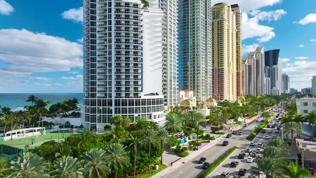 Aerial view of Sunny Isles Beach city with congested street traffic and luxurious highrise hotels and condos on Atlantic ocean shore. American tourism infrastructure in southern Florida