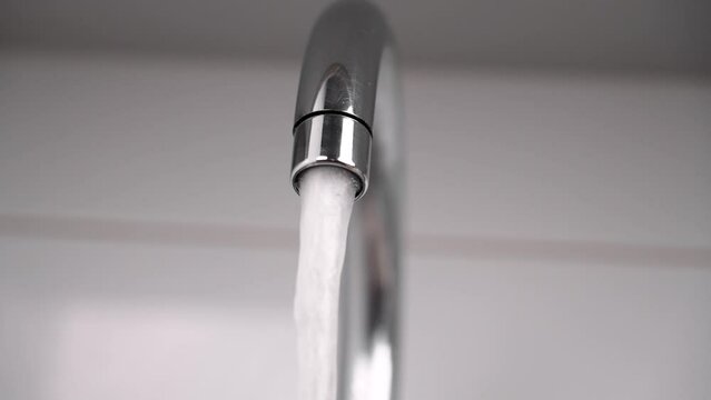 Turning on the kitchen faucet and starting the flow of clean drinking water from the faucet