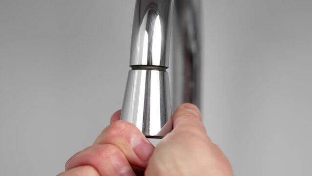 Plumber sets aerator on a kitchen faucet close up. Home technical service concept