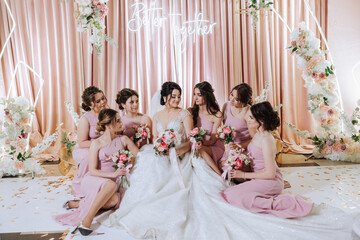 Group portrait of the bride and bridesmaids. Bride in a wedding dress and bridesmaids in pink or...