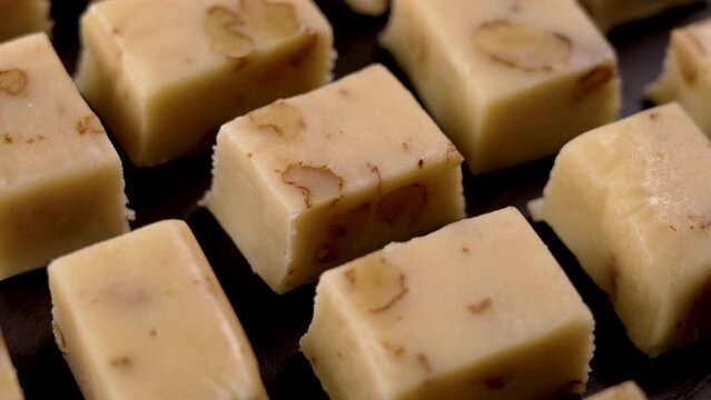 Classic Spanish sliced Turron with almond nuts stacked in a rows close up. Rotation