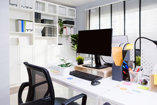 Modern mockup open space of personal desk office with monitor with clipping path display, keyboard, mouse, pen and a paper on the table in modern workspace. Real interior with nobody office image.