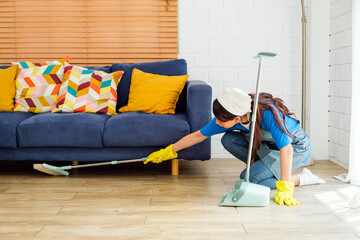 Young professional cleaning service women worker working in the house. Girls housekeeper sweeps...
