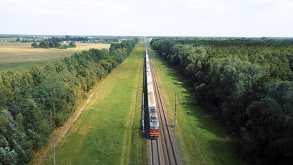 Electric train with freight cars or railway passenger wagon rides on railroad. Transportation...