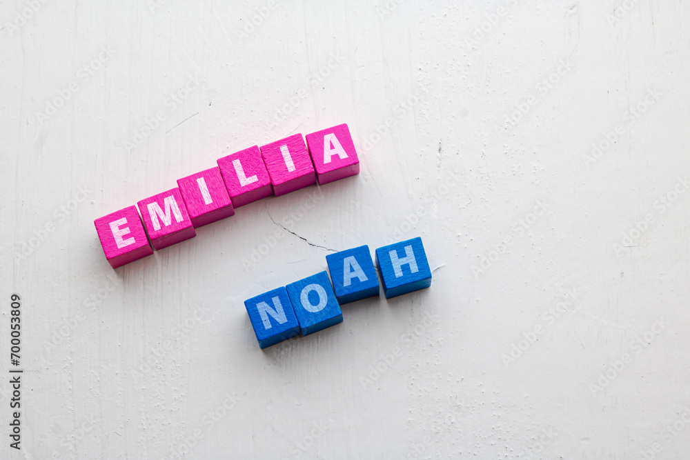 Fototapete given names emilia and noah, most common in germany 2023 placed on colorful wooden blocks on a rough