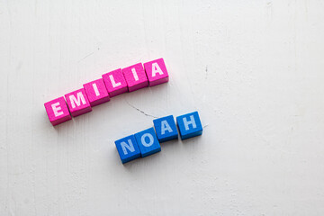 Given Names Emilia and Noah, most common in Germany 2023 placed on colorful wooden blocks on a rough wooden surface - obrazy, fototapety, plakaty