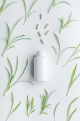 Herbal organic medicines with green leaves and pills in white bottle