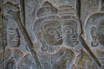 Ancient asian stone wall carving of human faces in temple in Cambodia Angkor Wat Siem Reap