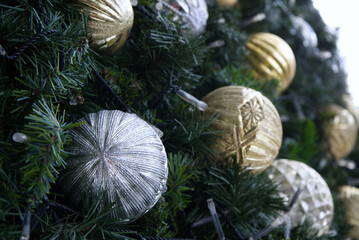 Closeup of a Snow Vinyl Christmas Tree decorated with silver and gold color balls, depth of field