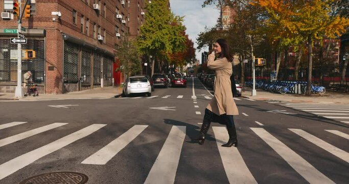 Attractive stylish female crossing the street in vibrant urban Manhattan landscape on sunny day