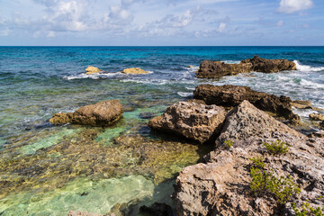 Tropical sea, rocks, cliffs and turquoise Caribbean Sea, Playa del Norte beach in Isla Mujeres, Mexico