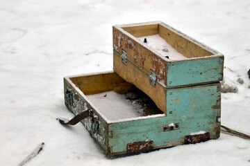 broken old wooden box with lock in snow