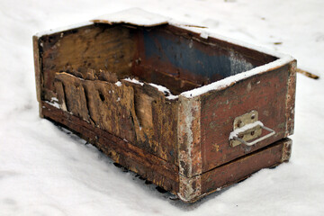 broken old wooden box with lock in snow