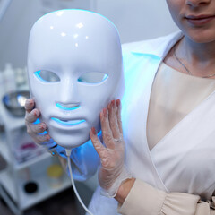 Woman getting cosmetic procedure with LED facial mask. , photon therapy