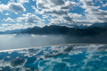 Fototapeta na wymiar Mountain with clouds sky reflection with water in infinity pool in Sa Pa, Vietnam