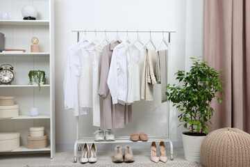 Rack with different stylish women`s clothes and shoes indoors