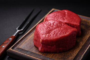 Fresh juicy raw filet mignon with salt, spices and herbs