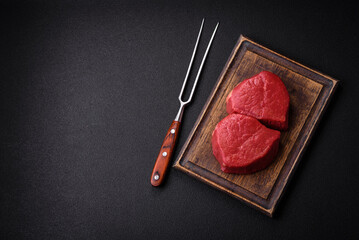 Fresh juicy raw filet mignon with salt, spices and herbs