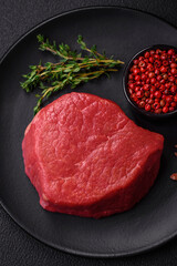 Fresh juicy raw filet mignon with salt, spices and herbs