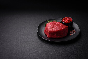 Fresh juicy raw filet mignon with salt, spices and herbs