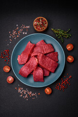 Juicy fresh raw beef meat with salt, spices and herbs