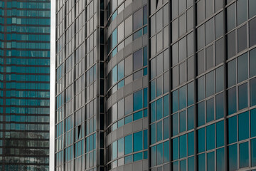 Fototapeta na wymiar modern office building in the city with glass windows blue reflection sky clouds