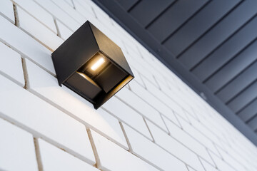 Halogen lamp in street lamp, economical lighting, ice lantern on the wall of the house, spot...