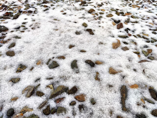 Texture of small stones with snow. Background of pebbles and ice. Abstract background, texture, pattern, frame, place for text and copy space