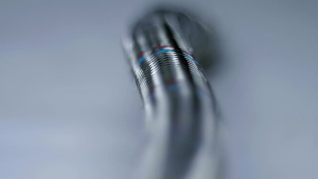 Metal braid structure to strengthen flexible plumbing hose. The same method is used in hoses to compensate pressure in pneumatic and hydraulic equipment. Closeup. Macro. Shallow depth of field