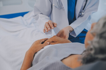 Doctor taking care, help and encourage Asian elder senior woman patient in clinic hospital.