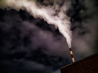 Winter night industrial landscape. Coal-fired power station with smoking chimneys against dramatic...