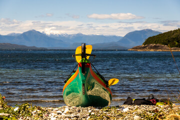 sea kayak on a beach in the chonos archipelago, patagonia, chile with sea and mountains in backbground room for text