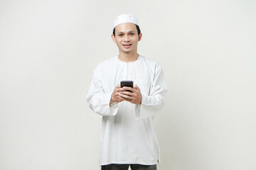 happy muslim man holding mobile phone. People religious Islam lifestyle concept. celebration Ramadan and ied Mubarak. on isolated background.