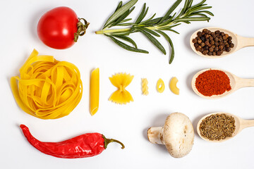 Raw pasta with spices and different vegetables on a white background