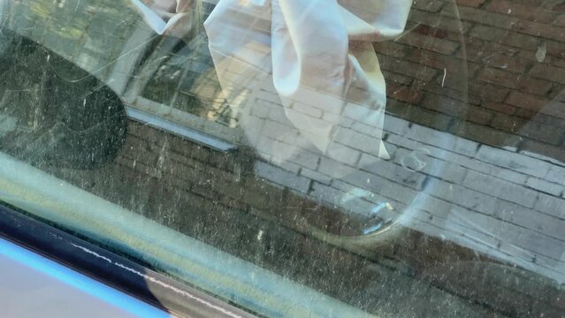 Side part of abandoned car, deployed airbag through dirty window