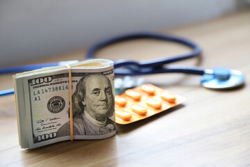 Concept of medical and pharmaceutical industry and making money. Wad of dollar bills and medicinal pills and medical items. Medical economics. Drugs and money. - obrazy, fototapety, plakaty