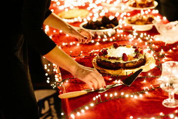 Cutting a cake with a glowy red background
