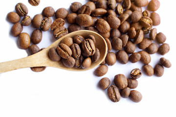 Coffee beans roasted in a wooden spoon and spread on a white background is a medium roast, the coffee taste is medium intensity. Slightly sweet and sour, suitable for both hot and cold coffee.