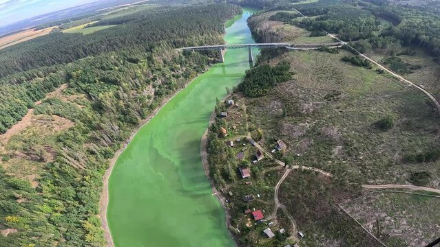 The bridge over Hracholusky dam with water power plant. The water reservoir on the river Mze.Source of renewable energy and popular recreational area in Bohemia. Czechia, aerial panorama. green water
