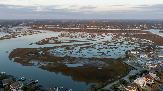 Aerial shot of Wrightsville Beach, North Carolina, showcasing the contrast between the dense marshland and the developed coastline at dusk.