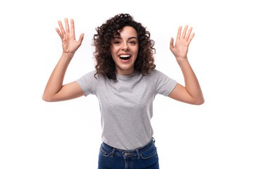 portrait of a young joyful 30 year old caucasian woman in a gray t-shirt with a mockup for printing on a white background with copy space