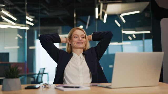 Happy caucasian business woman relax sit at office desk finished laptop computer work put hands behind head feel satisfied with work well done stress relief peace of mind concept chill at work.