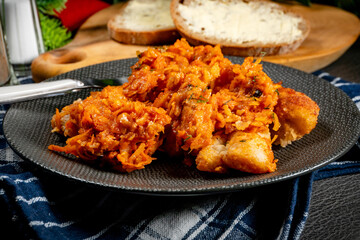 Fish in Greek kind with vegetables and tomato sauce.