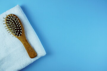 Wooden Comb and towel on blue background