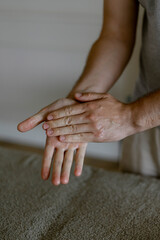 Massage therapist's hands rub oil in palms
